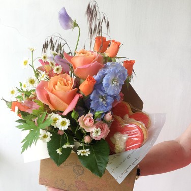 Композиция в конверте из цветов и печенья