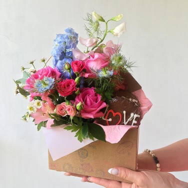 Композиция в конверте из полевых цветов и печенья