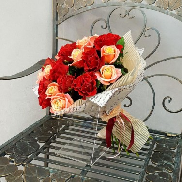 Букет из алых и коралловых роз в дизайнерской упаковке
