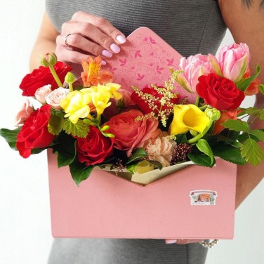 Композиция в конверте из роз, фрезий и ранункулюсов