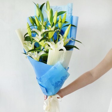 Красивый букет из белых лилий в упаковке