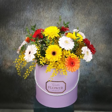 Композиция в шляпной коробке из минигербер и мимозы