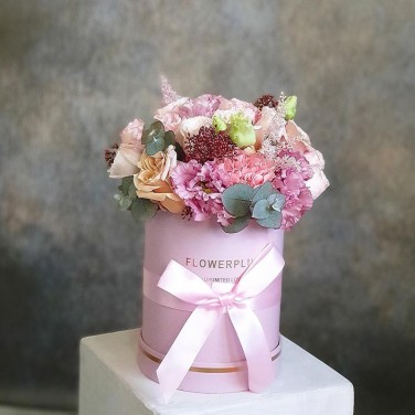 Композиция в шляпной коробке из пионовидных роз, астильбы и скиммии Оникс