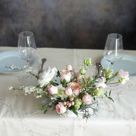 Нежная композиция на праздничный стол из роз, эустомы и зелени