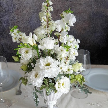 Белая композиция на стол из прунуса, эустомы и зелени