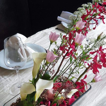 Оригинальная композиция на стол из калл, орхидей и прунуса