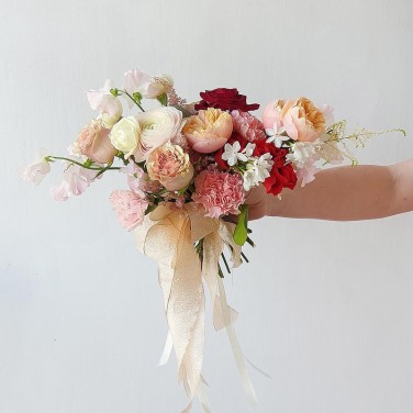 Свадебный букет оригинальной формы из роз, ранункулюсов и латируса