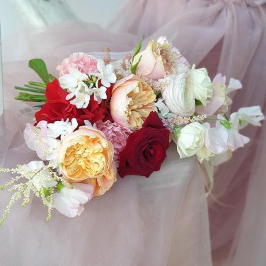 Свадебный букет оригинальной формы из роз, ранункулюсов и латируса