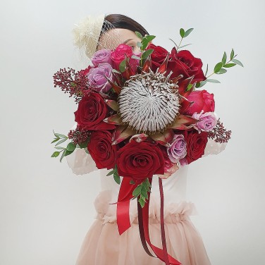 Красный свадебный букет из протеи, роз и скиммии