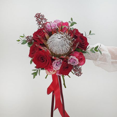 Красный свадебный букет из протеи, роз и скиммии