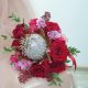 Красный свадебный букет из протеи, роз и скиммии