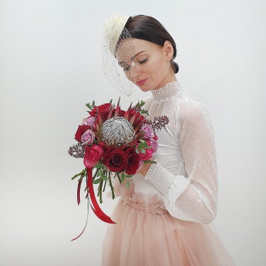 Красный свадебный букет из протеи, роз и скиммии