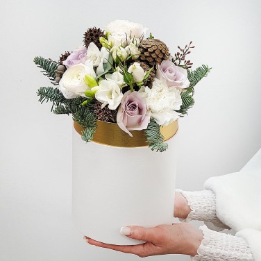 Зимняя композиция в шляпной коробке из ранункулюса, фрезии и шишек