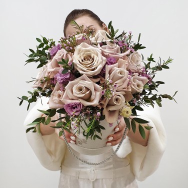 Композиция в белой шляпной коробке из пудровых роз и эвкалипта