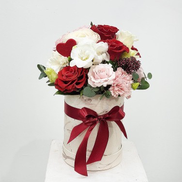 Композиция в шляпной коробке из роз и ранункулюса