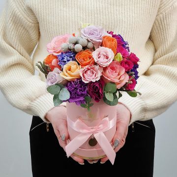 Композиция в шляпной коробке из разноцветных роз и капса